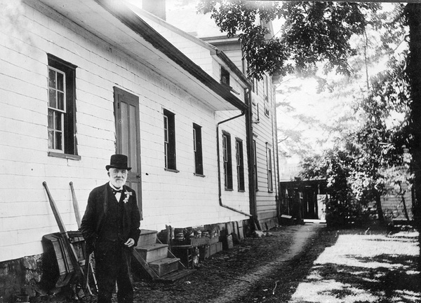 Dr. John Sebastian Helmcken in front of his Elliot Street residence in Victoria.